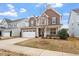 Inviting two-story home boasts a stone facade, two-car garage, and well-manicured lawn at 2005 Ernesto Ln, Raleigh, NC 27603