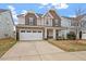 Inviting two-story home boasts a stone facade, two-car garage, and well-manicured lawn at 2005 Ernesto Ln, Raleigh, NC 27603