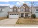 Inviting two-story home boasts a stone facade, two-car garage, and well-manicured lawn at 2005 Ernesto Ln, Raleigh, NC 27603