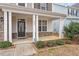 Welcoming front porch featuring stone accents, white columns, and manicured landscaping at 2005 Ernesto Ln, Raleigh, NC 27603