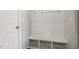 Mudroom with white wainscoting, coat hooks, and built-in bench with cubbies for storage at 2005 Ernesto Ln, Raleigh, NC 27603
