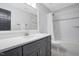 Bathroom with modern vanity, white tile shower, and dark gray cabinets at 206 Hamby St, Clayton, NC 27520
