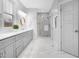 Bathroom with double vanity, gray cabinetry, quartz countertops, and a tiled shower at 206 Hamby St, Clayton, NC 27520