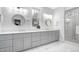 Bathroom with double vanity, gray cabinetry, quartz countertops, and a tiled shower at 206 Hamby St, Clayton, NC 27520