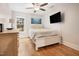 Bedroom with wood floors features a white bed, ceiling fan, TV and natural light at 206 Hamby St, Clayton, NC 27520