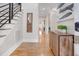 An entry featuring hardwood floors, stairs with black railings, a unique wooden mirror and stylish console table at 206 Hamby St, Clayton, NC 27520