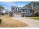A blue two-story home featuring stone accents, a well maintained yard, and a concrete driveway and walkway at 206 Hamby St, Clayton, NC 27520