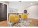 Hallway seating area with two yellow chairs and stylish rug, featuring wooden floor and natural light at 206 Hamby St, Clayton, NC 27520
