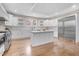 Bright kitchen featuring a large island, white cabinetry, stainless steel appliances, and wood flooring at 206 Hamby St, Clayton, NC 27520