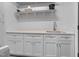 Well-lit laundry room featuring a sink, cabinets, and shelving for storage and organization at 206 Hamby St, Clayton, NC 27520