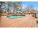 Inviting backyard pool area with a wooden deck featuring lounge chairs and a table, ideal for relaxation at 206 Hamby St, Clayton, NC 27520