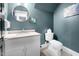 Stylish half-bath with blue walls and a round mirror at 206 Hamby St, Clayton, NC 27520