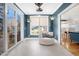 Well-lit sunroom featuring blue walls, pendant plants, window, tile floors, and a comfortable chair at 206 Hamby St, Clayton, NC 27520