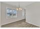 Bright dining room with a chandelier, wood-look flooring, and large window for natural light at 252 Olde Place Dr, Zebulon, NC 27597
