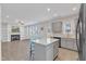 Kitchen island featuring modern gray cabinets and counter seating, connects kitchen and living space with fireplace at 252 Olde Place Dr, Zebulon, NC 27597
