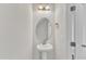 Clean and simple half-bathroom features a pedestal sink, oval mirror and neutral walls at 252 Olde Place Dr, Zebulon, NC 27597