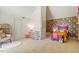 Whimsical bedroom with a pink bed, floral accent wall, and a cozy reading nook with a rattan chair at 2602 Vintage Hill Ct, Durham, NC 27712