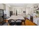 Bright kitchen features white cabinetry, stainless steel appliances, island with seating, and wood floors at 2602 Vintage Hill Ct, Durham, NC 27712