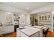 Bright kitchen features white cabinetry, stainless steel appliances, island with seating, and wood floors at 2602 Vintage Hill Ct, Durham, NC 27712