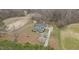 Property aerial view displaying the home's setting, outbuildings, landscaping and access road at 3068 Benson Rd, Angier, NC 27501