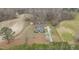 Aerial view shows the house, outbuildings, driveway, farmland, and perimeter trees at 3068 Benson Rd, Angier, NC 27501