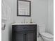 Bathroom features dark wood vanity with white countertop, faucet, mirror and toilet at 3068 Benson Rd, Angier, NC 27501