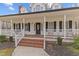 Inviting front porch with white railings, brick steps, and classic black shutters at 3068 Benson Rd, Angier, NC 27501