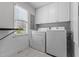 Bright laundry room with white washer and dryer and window at 3068 Benson Rd, Angier, NC 27501