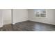 Bright bedroom with hardwood floors and neutral paint with a large window and a glimpse of the closet space at 31 Black Creek Dr, Lillington, NC 27546