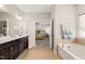 Bathroom view showcasing a dual sink vanity and a soaking tub leading into an adjacent bedroom at 3356 Longleaf Estates Dr, Raleigh, NC 27616