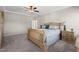 Light filled bedroom with carpeted floors and a decorative bed complimented with matching nightstands and lamps at 3356 Longleaf Estates Dr, Raleigh, NC 27616
