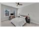 Cozy bedroom with large windows, a desk with computer, ceiling fan and neutral decor at 372 Natsam Woods Way, Wake Forest, NC 27587