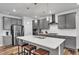Modern kitchen features a large island with leather stools and stainless steel appliances at 372 Natsam Woods Way, Wake Forest, NC 27587