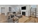 Comfortable living area features a cozy gray sofa, fireplace with TV above, and stylish decorative shelving at 372 Natsam Woods Way, Wake Forest, NC 27587