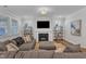 Bright living room showcases a fireplace with TV, decorative shelving, and comfortable seating on a gray sofa at 372 Natsam Woods Way, Wake Forest, NC 27587