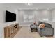 Cozy loft-style living room with a large TV, wood floors, and stylish decor with sofa and ottoman at 372 Natsam Woods Way, Wake Forest, NC 27587
