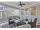 Cozy screened porch with a comfortable sofa, chairs, ceiling fan, and ample natural light at 372 Natsam Woods Way, Wake Forest, NC 27587