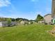 An exterior shot displays a sprawling green backyard, enclosed by a chain-link fence at 4 Hannah Ct, Durham, NC 27713