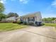Cozy home with a front porch, paved driveway, green lawn, and trimmed bushes at 4 Hannah Ct, Durham, NC 27713
