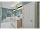 Bathroom featuring wallpaper, a double sink vanity, a free-standing tub, and natural light at 4007 Southpoint Landing Way, Durham, NC 27707