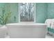 Freestanding bathtub with large window and scenic wooded view, complemented by patterned wallpaper at 4007 Southpoint Landing Way, Durham, NC 27707
