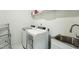 Functional laundry room equipped with a washer, dryer, sink, and storage shelves at 4007 Southpoint Landing Way, Durham, NC 27707