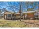 Back of brick home with deck and sunroom in a large yard at 411 Colony Woods Dr, Chapel Hill, NC 27517