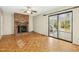 Living room features brick fireplace, hardwood floors, and sliding glass door to patio at 411 Colony Woods Dr, Chapel Hill, NC 27517