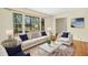 Beautifully staged living room with hardwood floors, bright white furniture, and large windows at 411 Colony Woods Dr, Chapel Hill, NC 27517