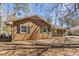 The side exterior shows the home's brick and wood facade, complemented by black shutters and lush surroundings at 411 Colony Woods Dr, Chapel Hill, NC 27517