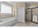 Bright bathroom featuring soaking tub, window, and glass shower at 420 Carsons Creek Trl, Wendell, NC 27591