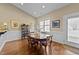 A dining area features hardwood floors, a wood table, and natural light from a window at 420 Carsons Creek Trl, Wendell, NC 27591