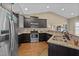 A kitchen features stainless steel appliances, dark cabinets, granite countertops, and hardwood floors at 420 Carsons Creek Trl, Wendell, NC 27591