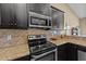 Kitchen features granite countertops, stainless steel appliances, tile backsplash, and dark cabinets at 420 Carsons Creek Trl, Wendell, NC 27591